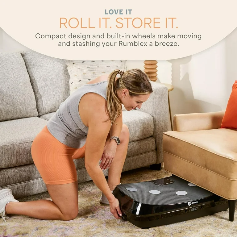 A woman pushes a Rumblex vibration plate under a couch to store it.